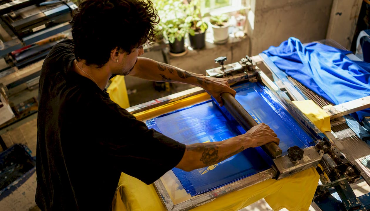 Hands screen-printing tour t-shirts