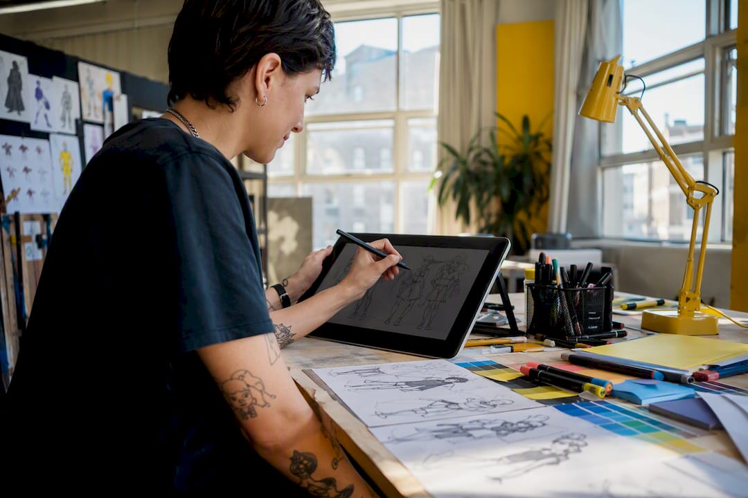 Hands sketching character art in animation studio