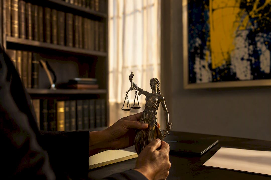 Hands holding Lady Justice statue in law office