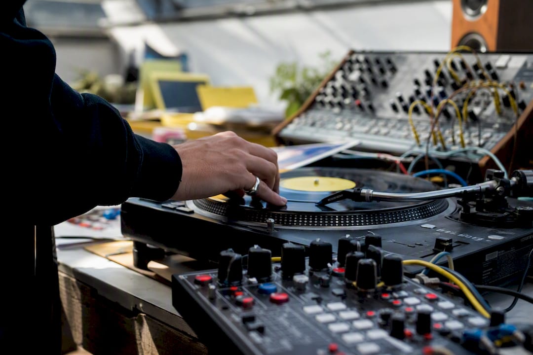 Musician’s hand adjusting vinyl on turntable