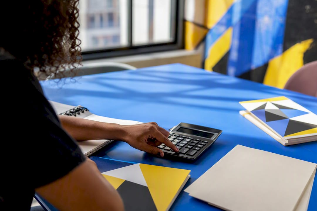Hands calculating budget at creative desk