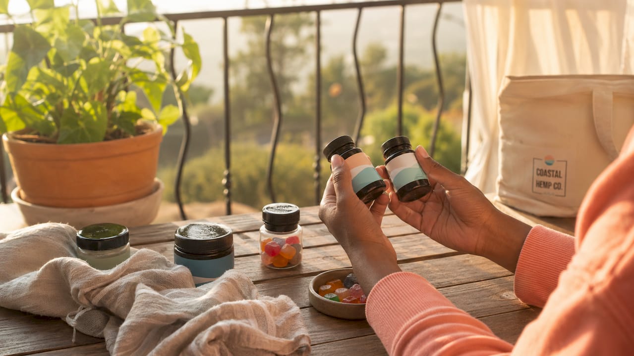 Overhead view of hands comparing hemp product dosages