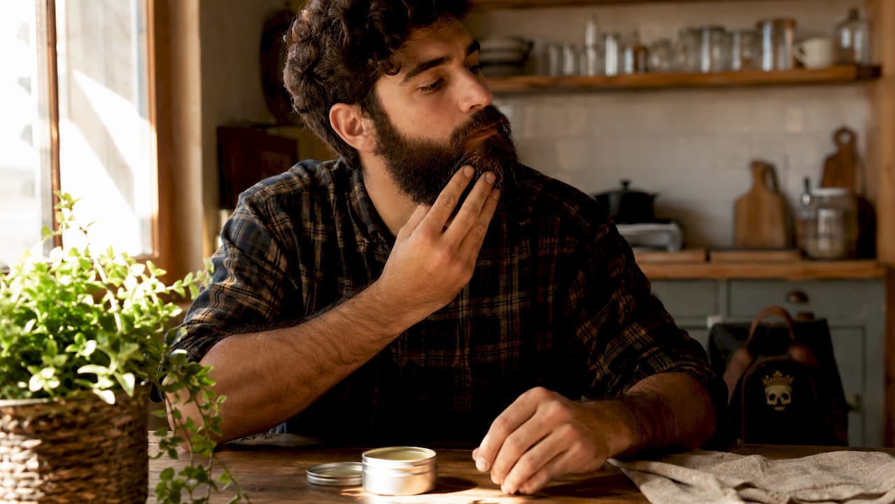 Man applying beard balm outdoors