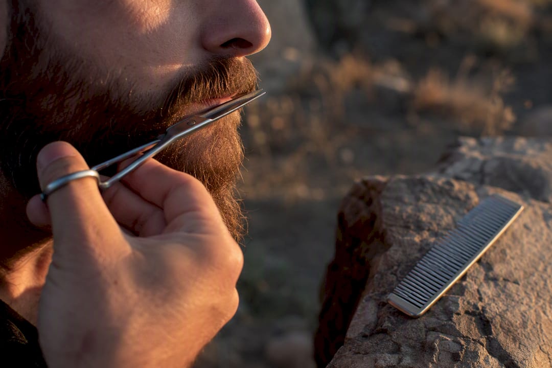 Mustache trimmed close-up with scissors and comb