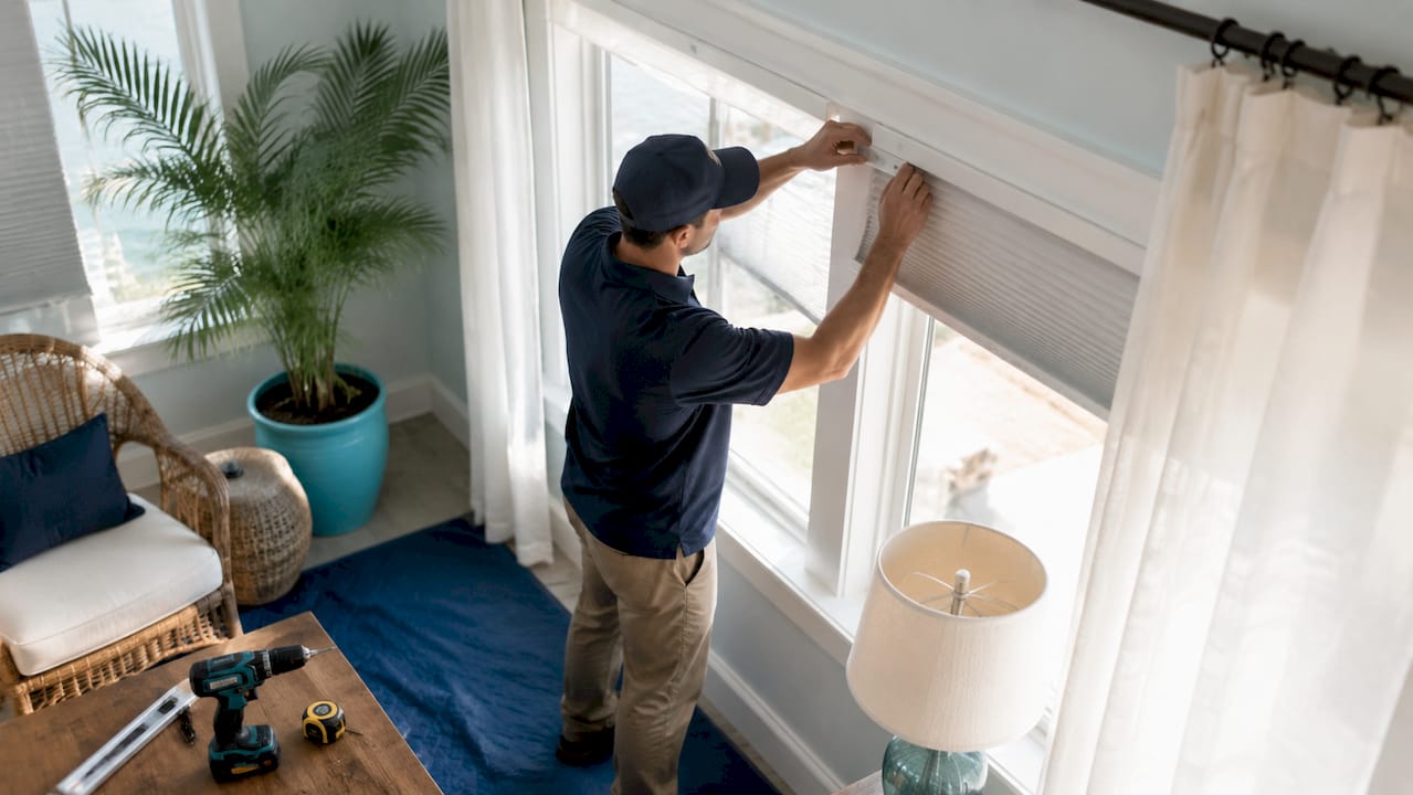 Installer fitting window blinds without disruption