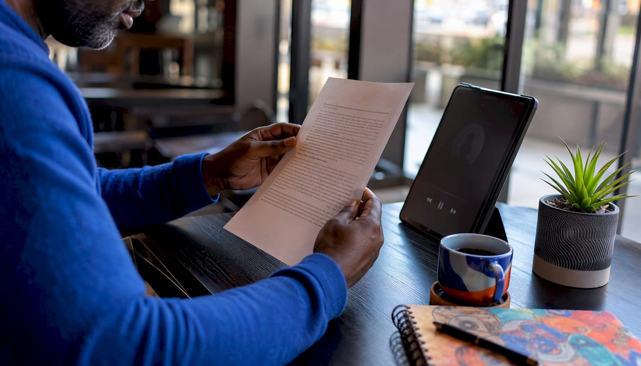 Hands holding indie ebook page in coworking space