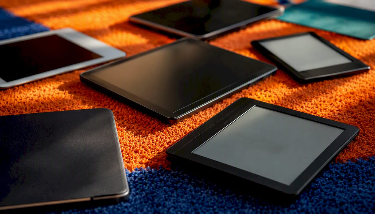 Dark screens of e-readers on colorful surface