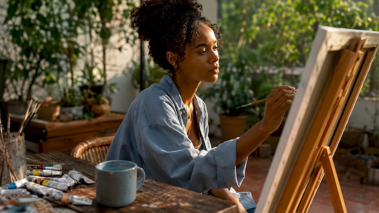 Woman painting in art studio focusing intensely