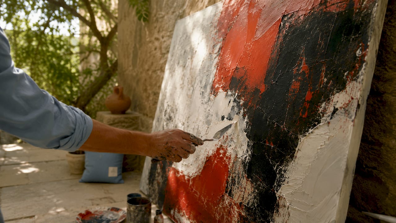 Close-up of artist working on large abstract painting