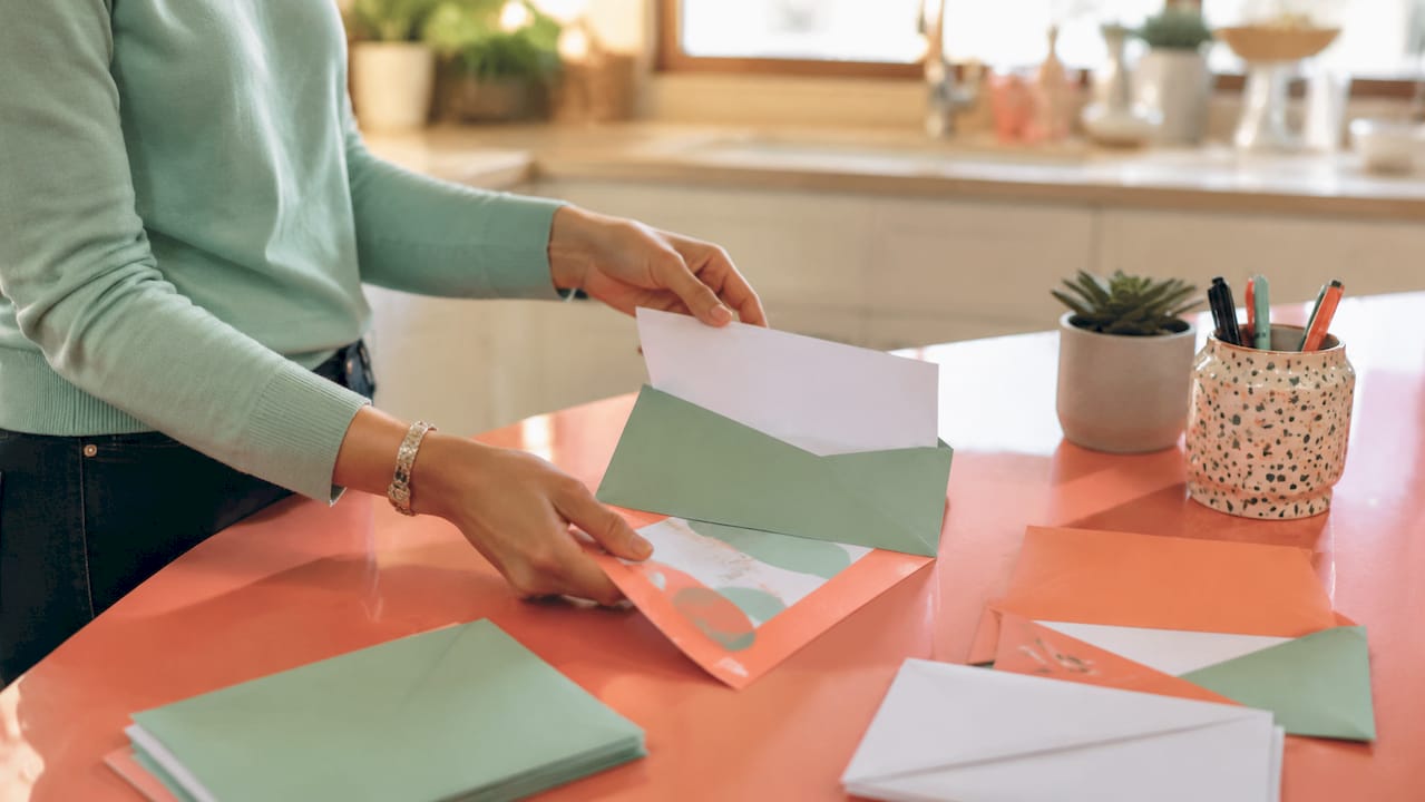 Hands assembling letter pack with direct mail inserts
