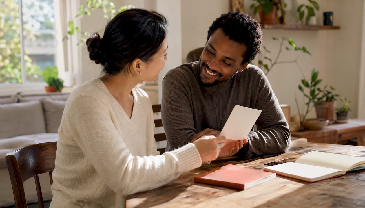 Hands exchanging appreciation card over table
