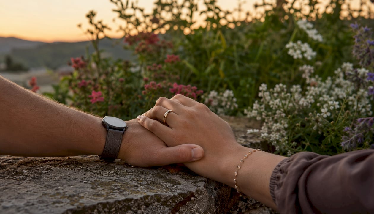 Close-up of couple’s hands holding on bench