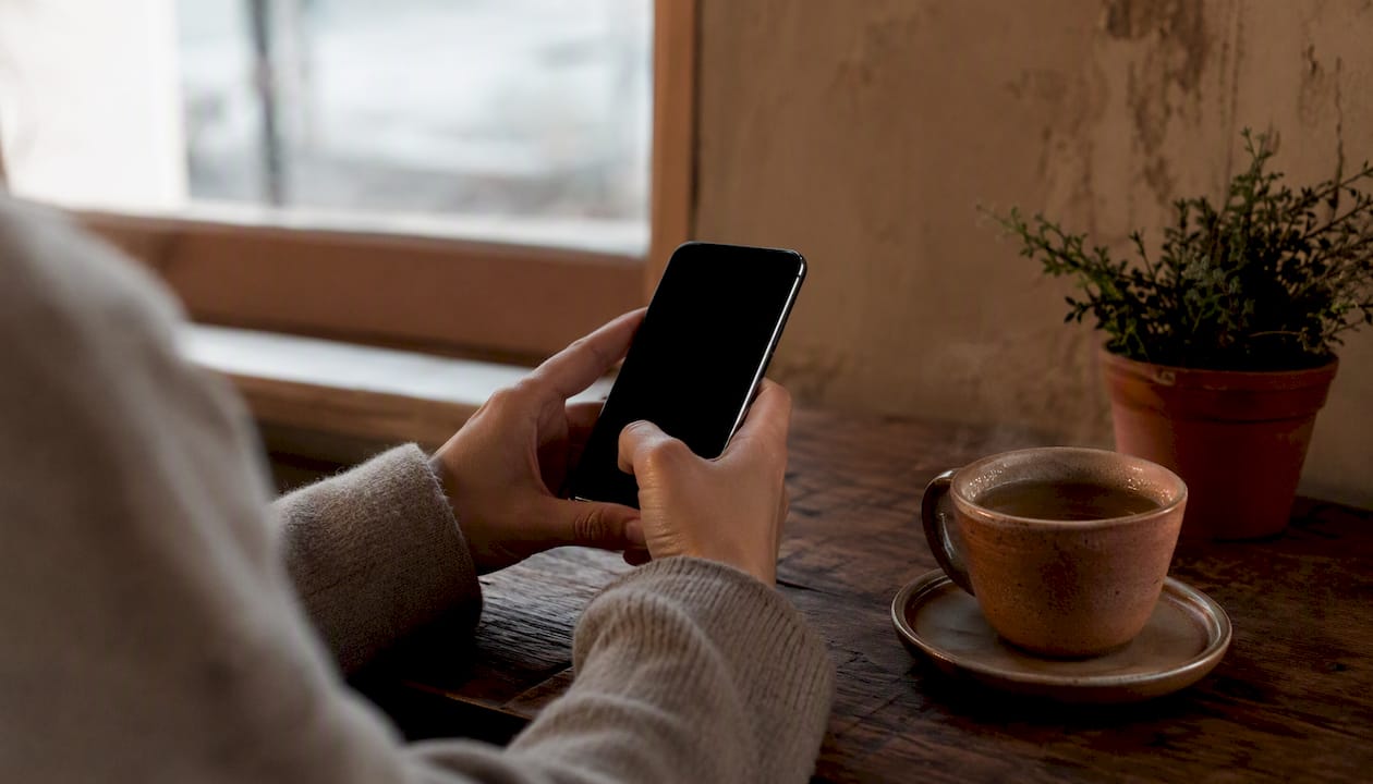 Hand sending thoughtful message from phone