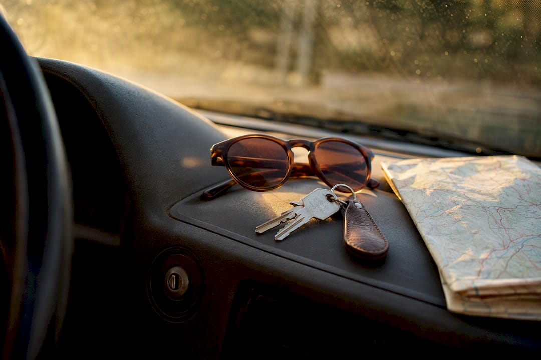 Car dashboard with keys and map for road trip