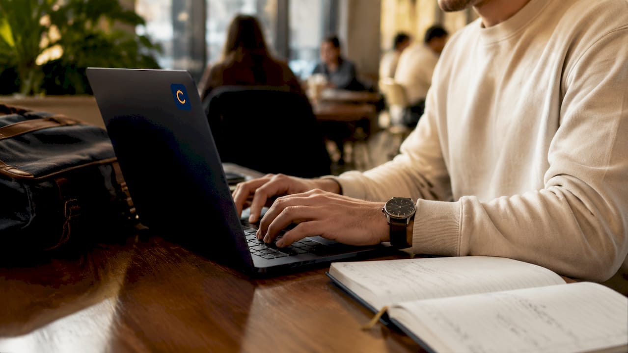 Hands typing on laptop in library study booth
