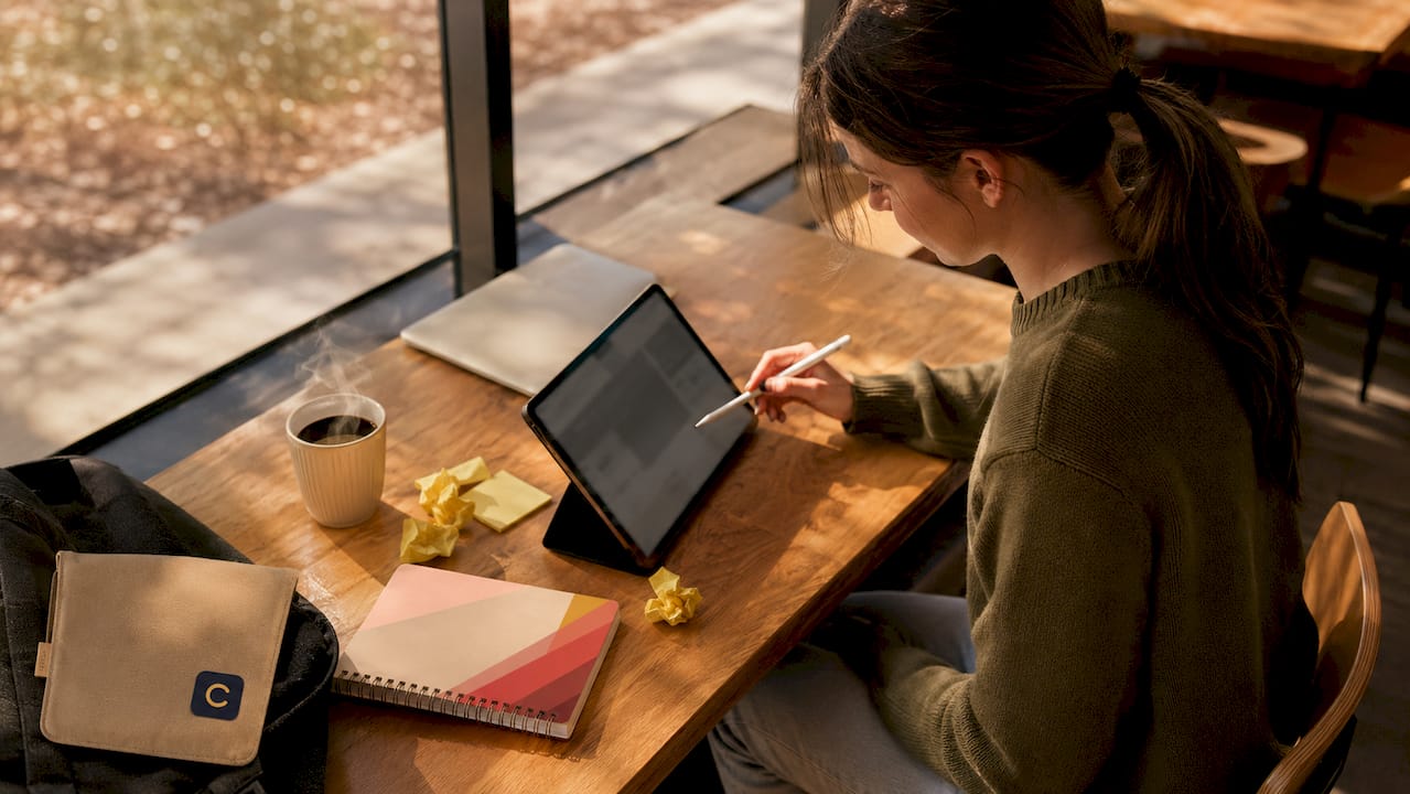 Hands selecting dropdown menus on tablet for assignment tracking