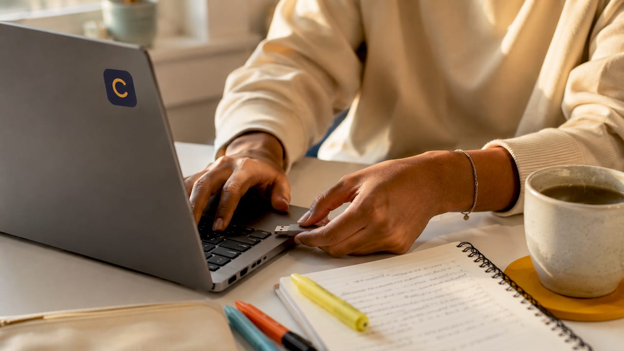 Hands plugging USB into laptop preparing assignment upload