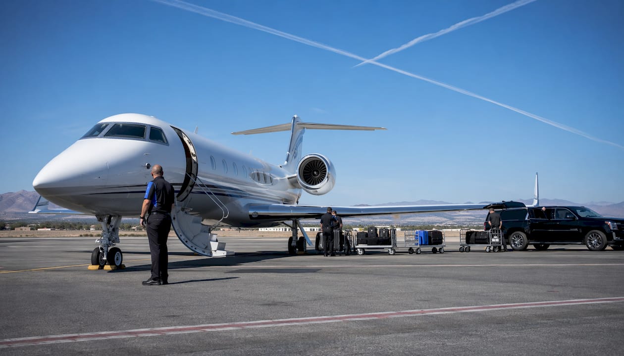 Private jet and ground crew on airport tarmac