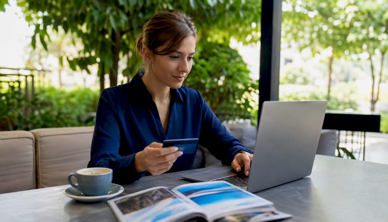 Hands with credit card and laptop in home office