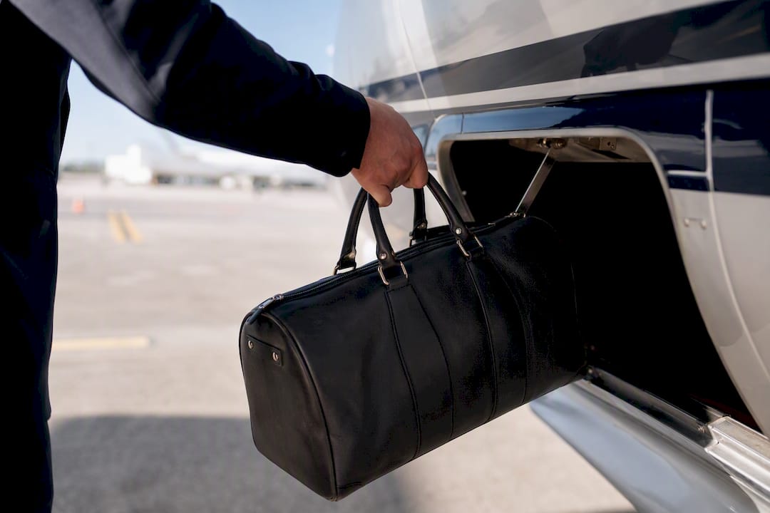 Leather travel bag loaded into private jet cargo hold