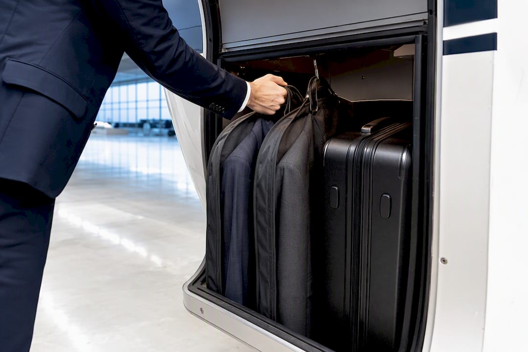Garment bags beside private jet cargo opening