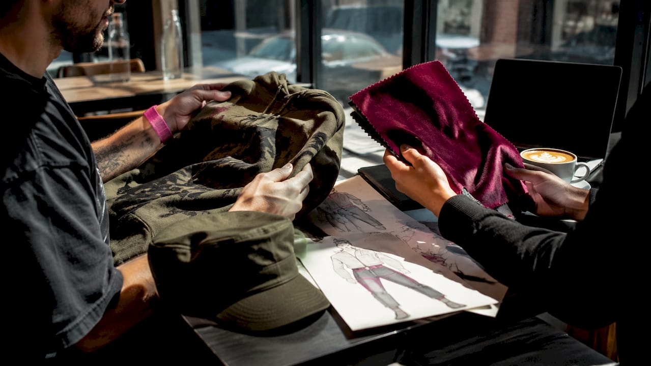 Hands comparing casual and formal military apparel fabrics