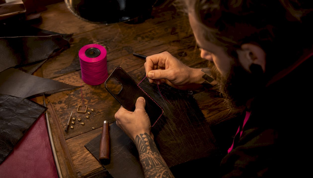 Hands stitching handcrafted leather phone case