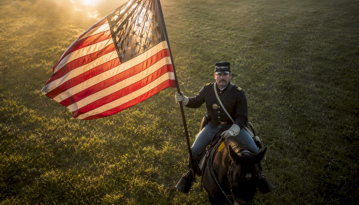 Cavalry soldier holding US flag with stars forward