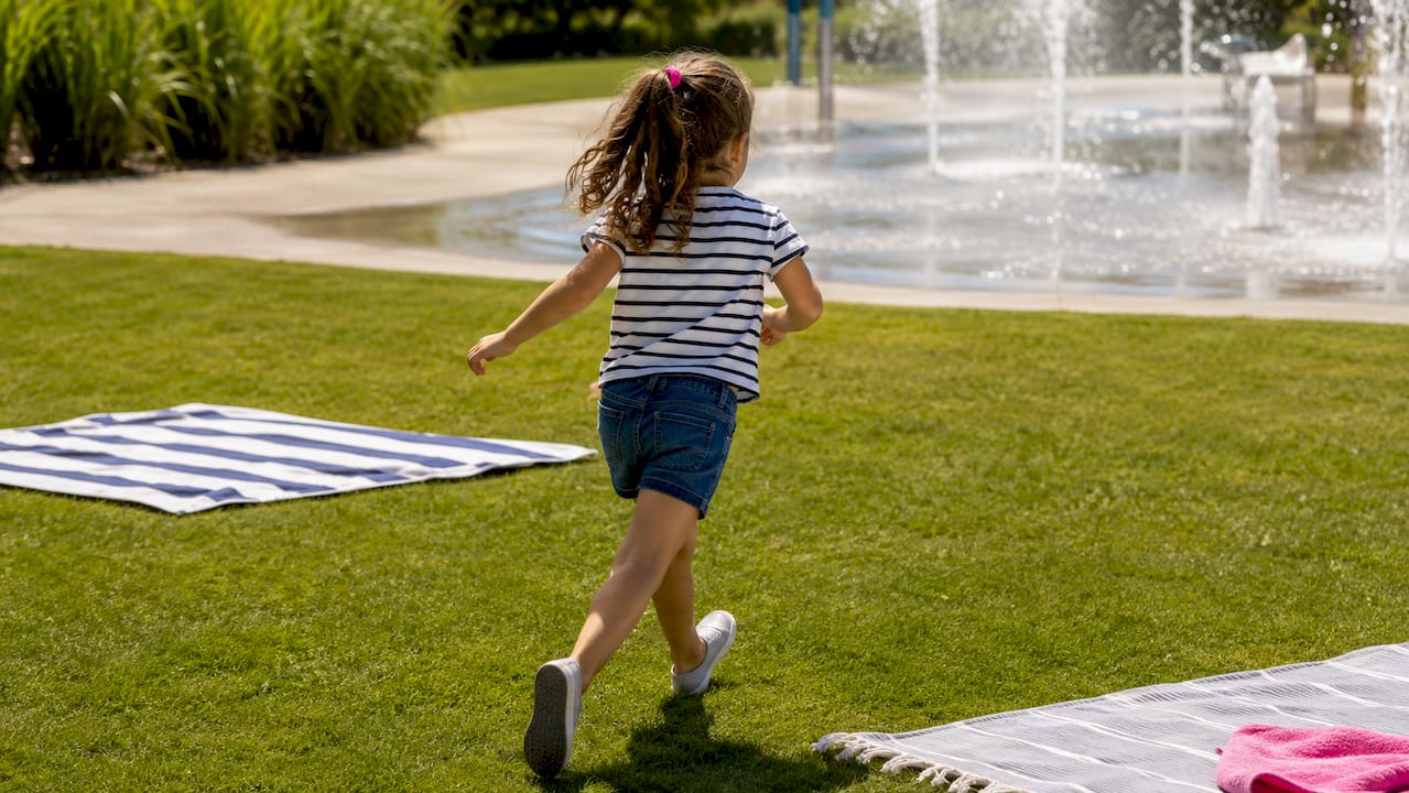 Child running outdoors in washable summer clothes