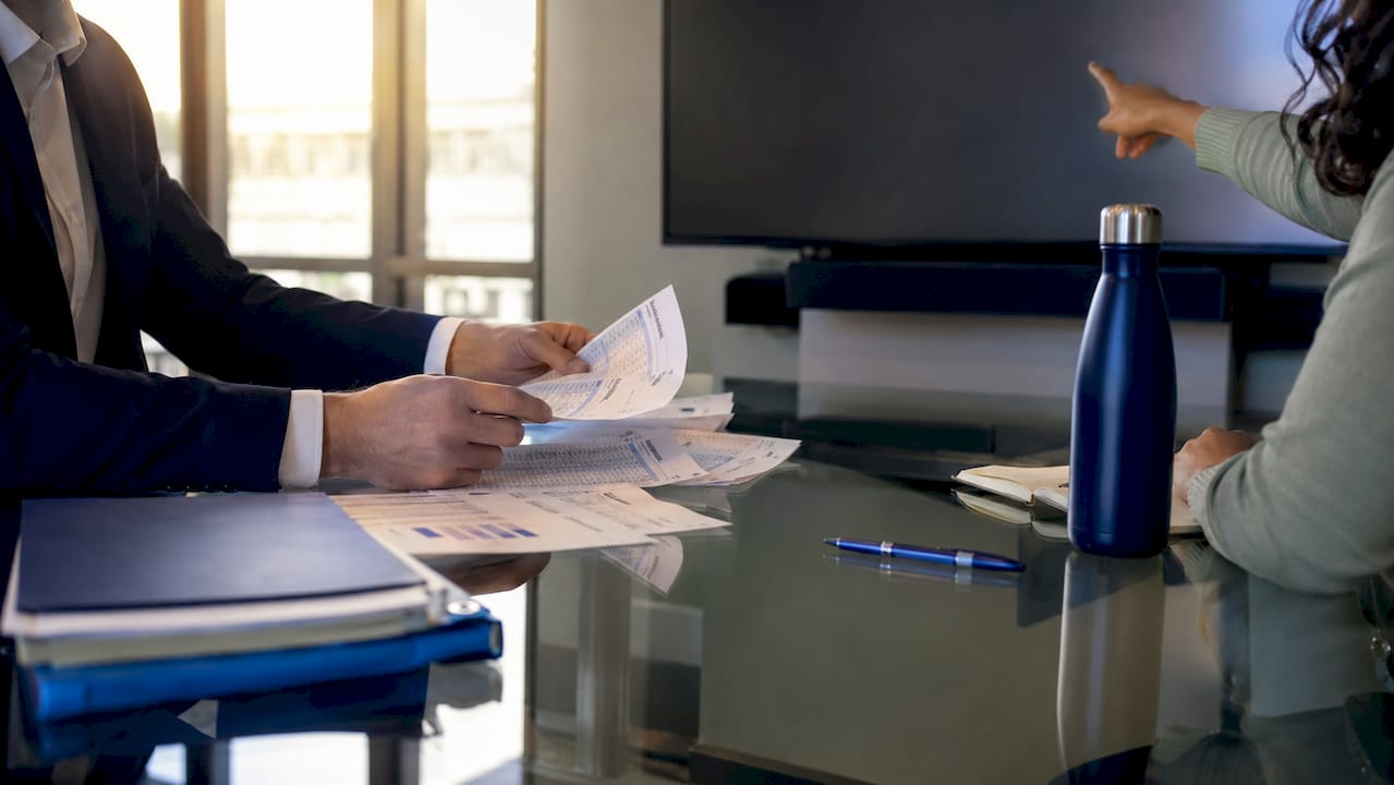Hands organizing business offer papers and tablet