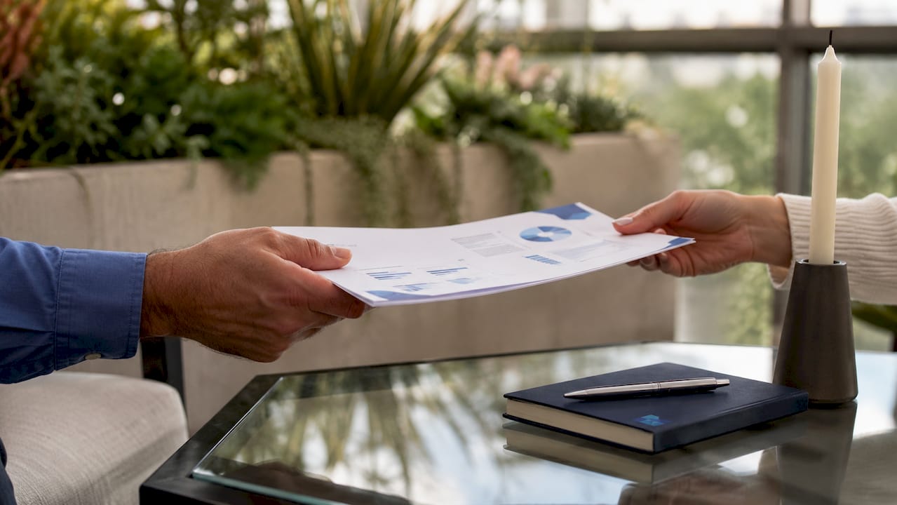 Hands exchanging business valuation report
