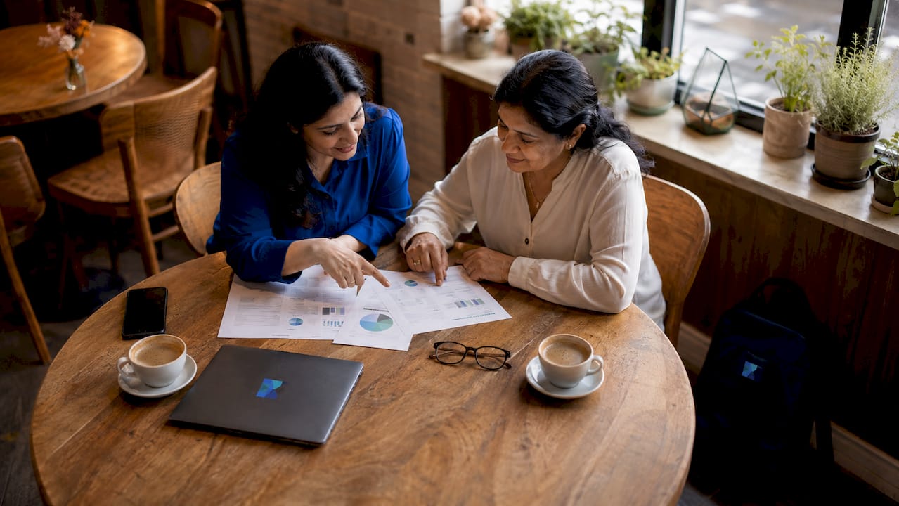 Two women collaborating over sale preparation materials