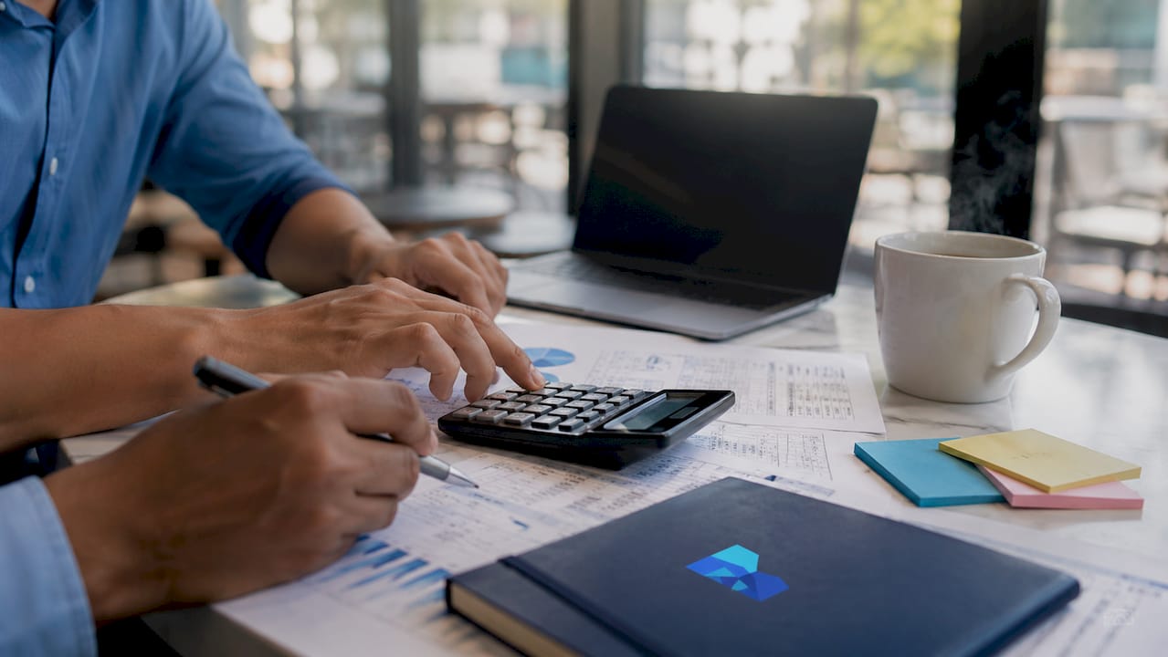 Hands calculating financial data with documents