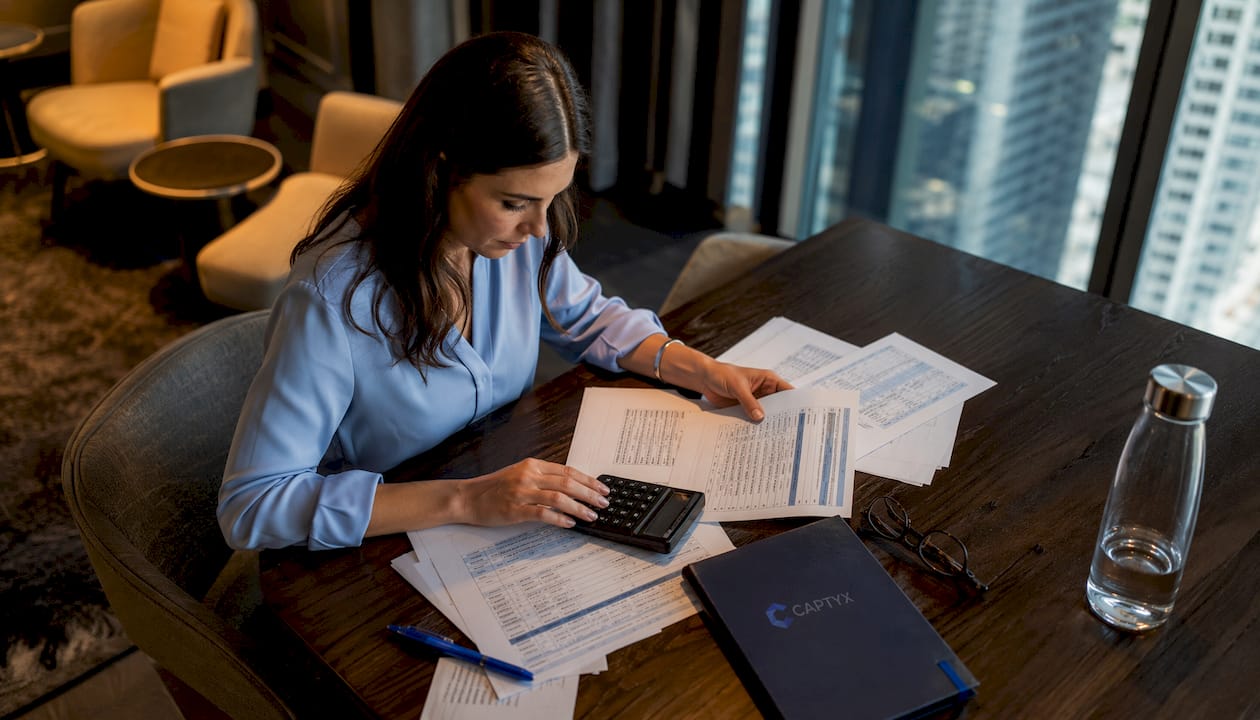 Woman calculating business valuation at desk