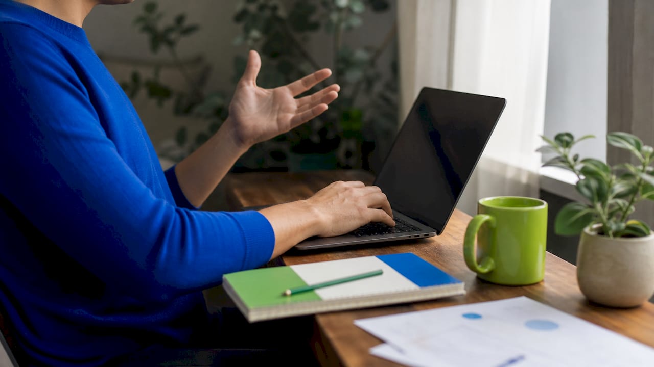 Hands frustrated by email overload on cluttered desk