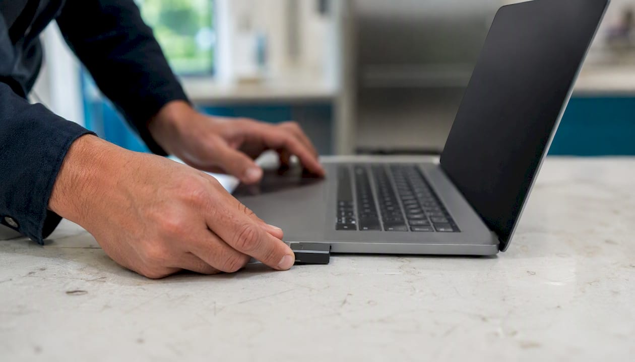 Hands reconnecting USB drive for data transfer