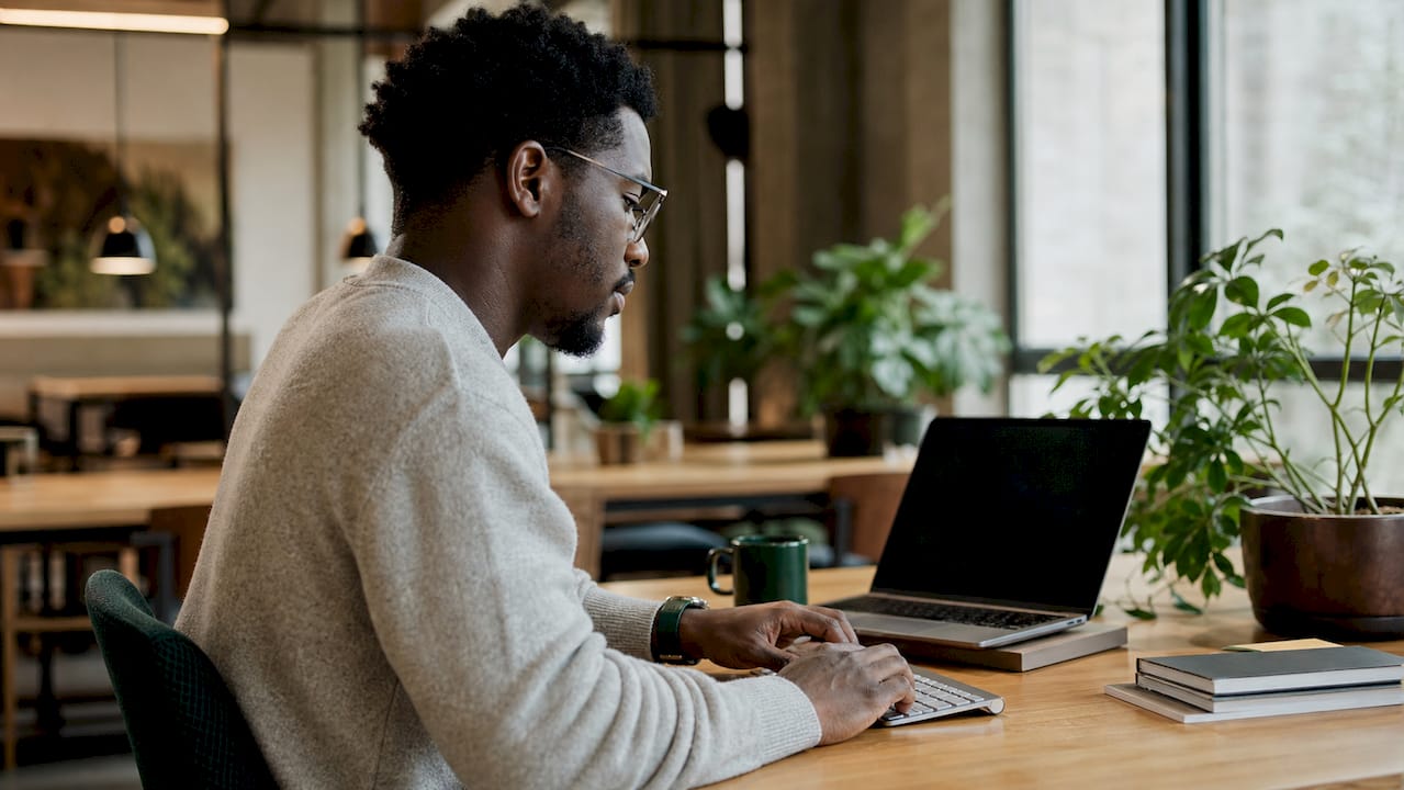 Young man prospecting on laptop in home office