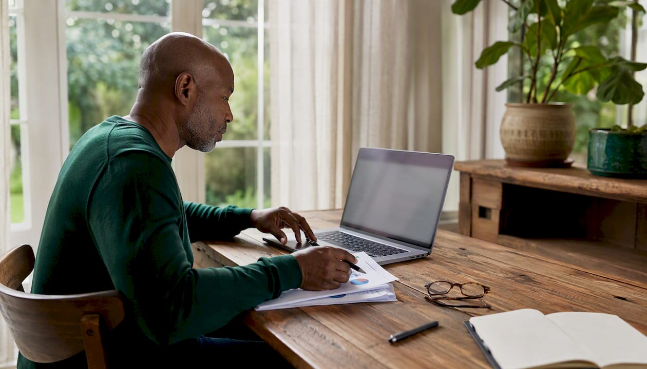 Hands analyzing buyer data on laptop in home office