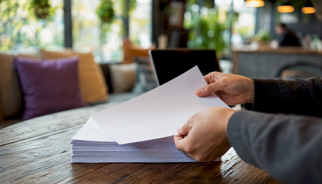 Hands handling a printed workflow checklist