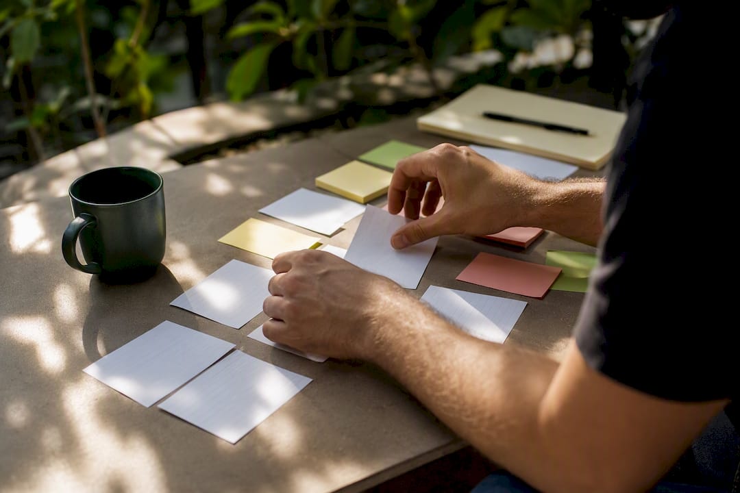 Hands sorting sales strategy notes on desk