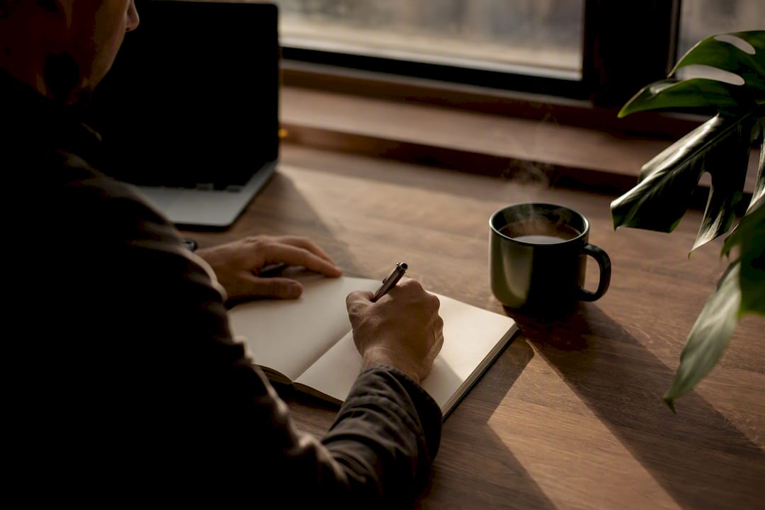 Hands writing strategic notes on desk