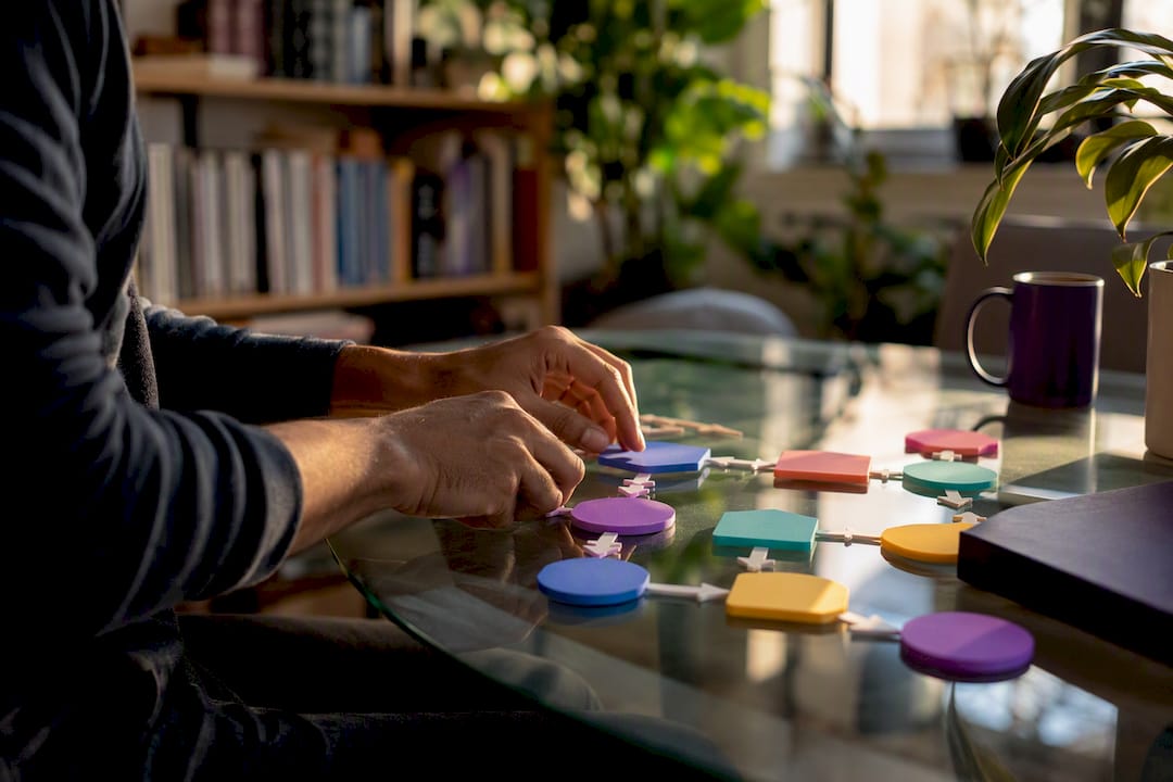 Hands assembling AI workflow tokens on desk