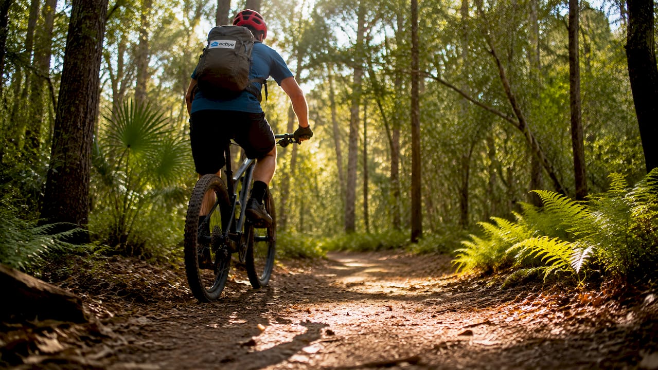 Cyclist on Gulf State Park trail surrounded by trees