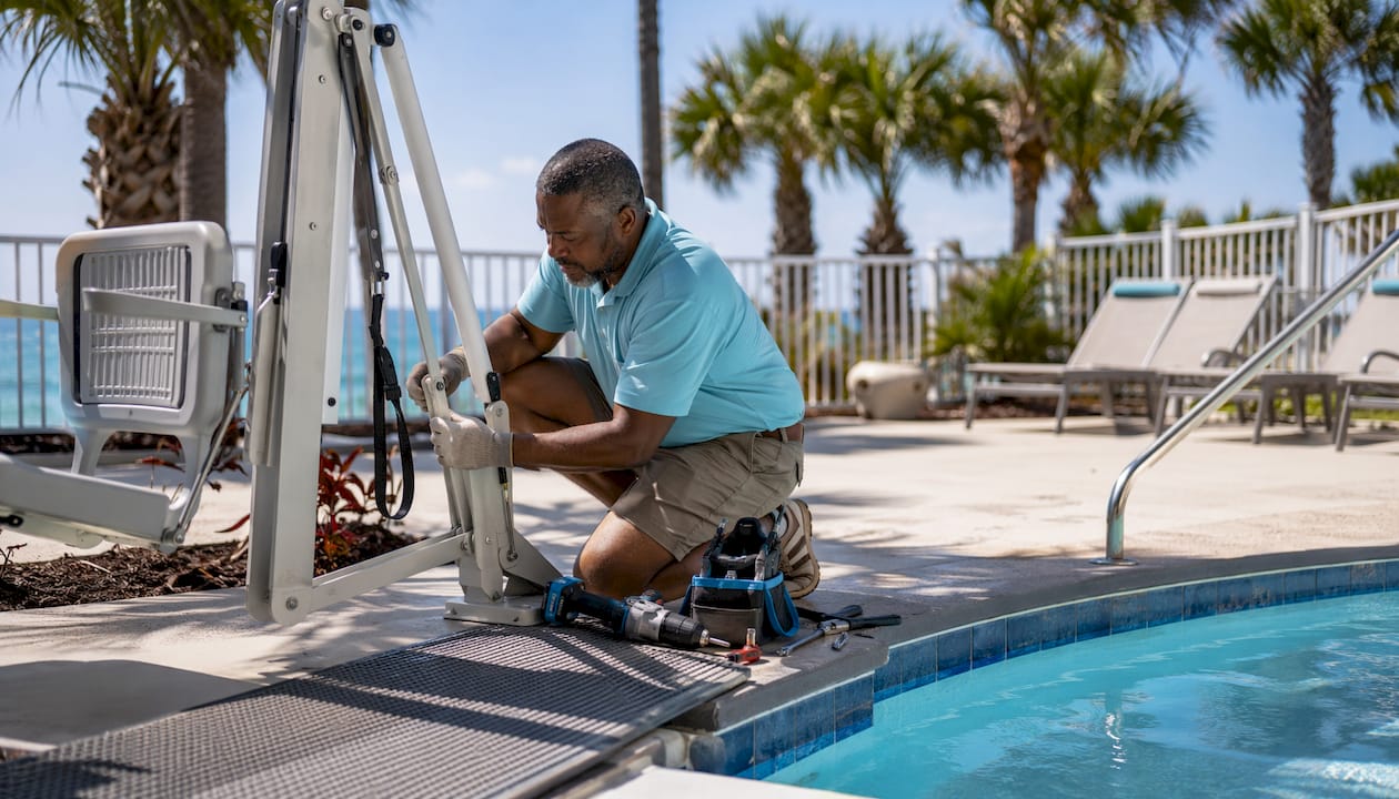 Technician installing wheelchair pool lift at Florida beach rental