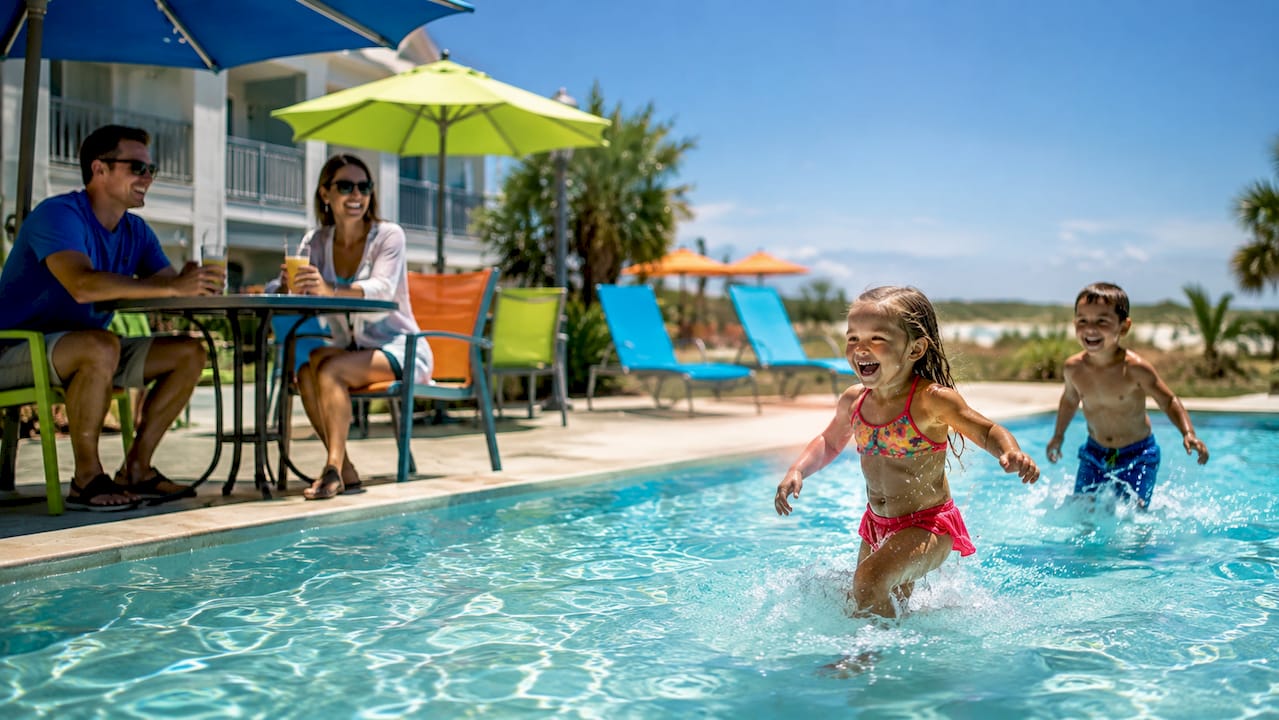 Family enjoying poolside at beachfront condo resort