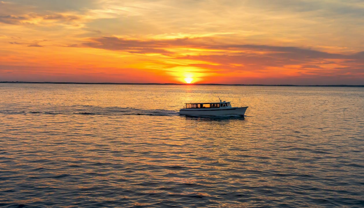 Silhouette of a sunset cruise boat on Gulf waters