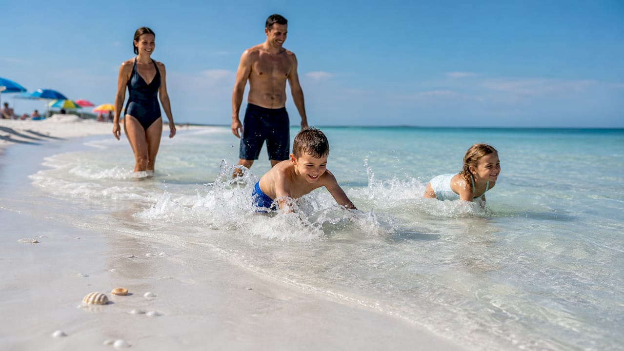 Family entering warm shallow Gulf Coast beach water