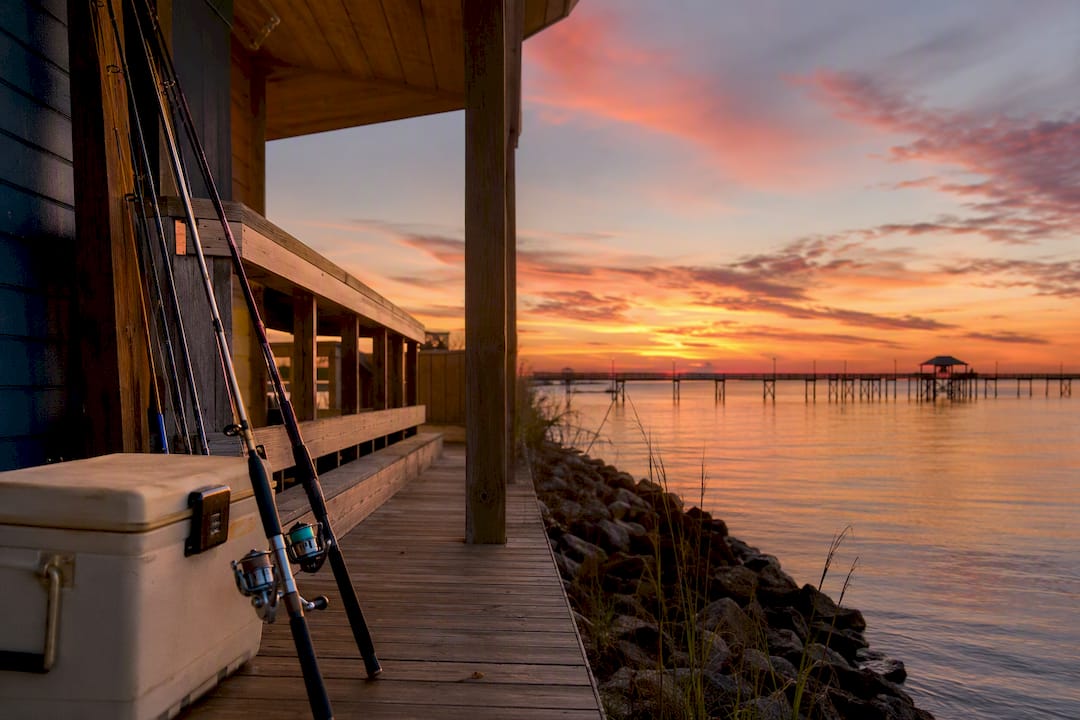 Vacation rental porch with fishing gear and pier view