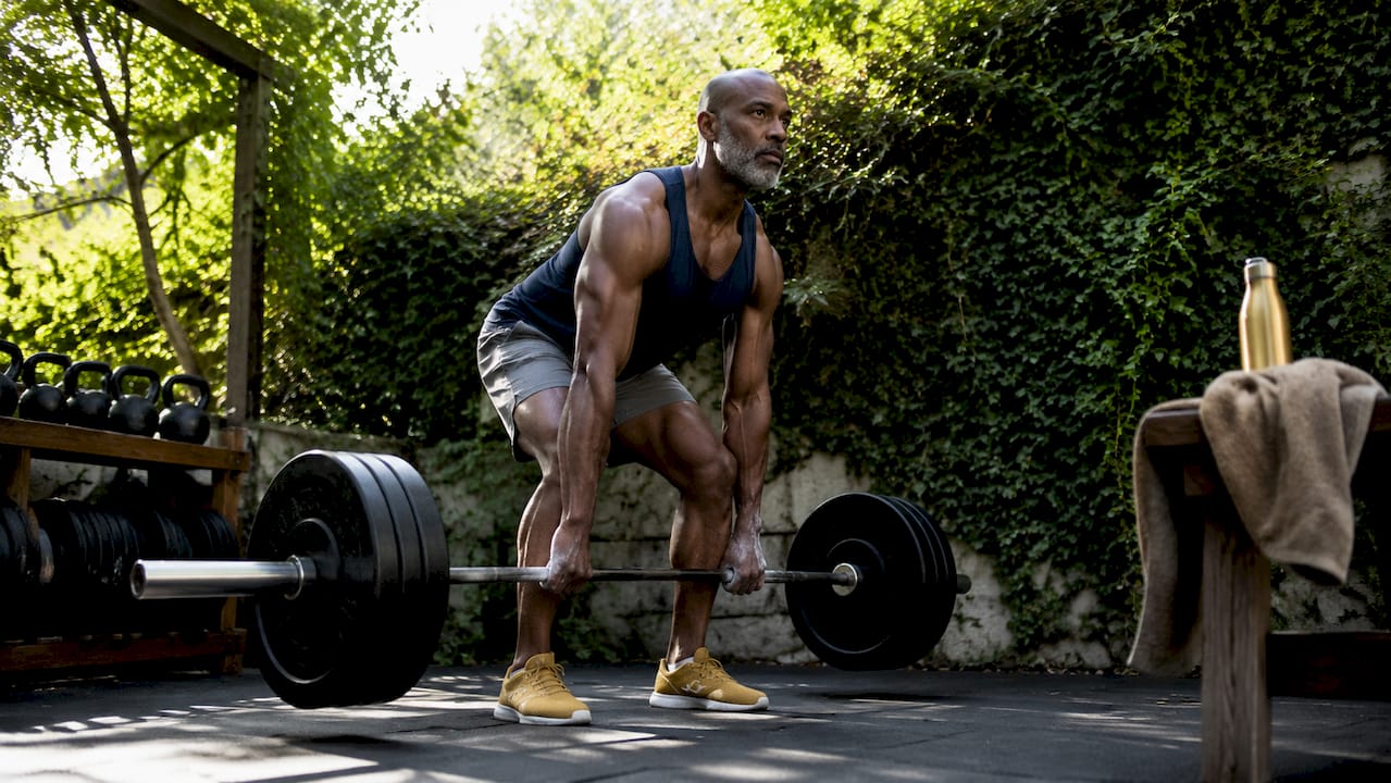 Mature man lifting weights in gym