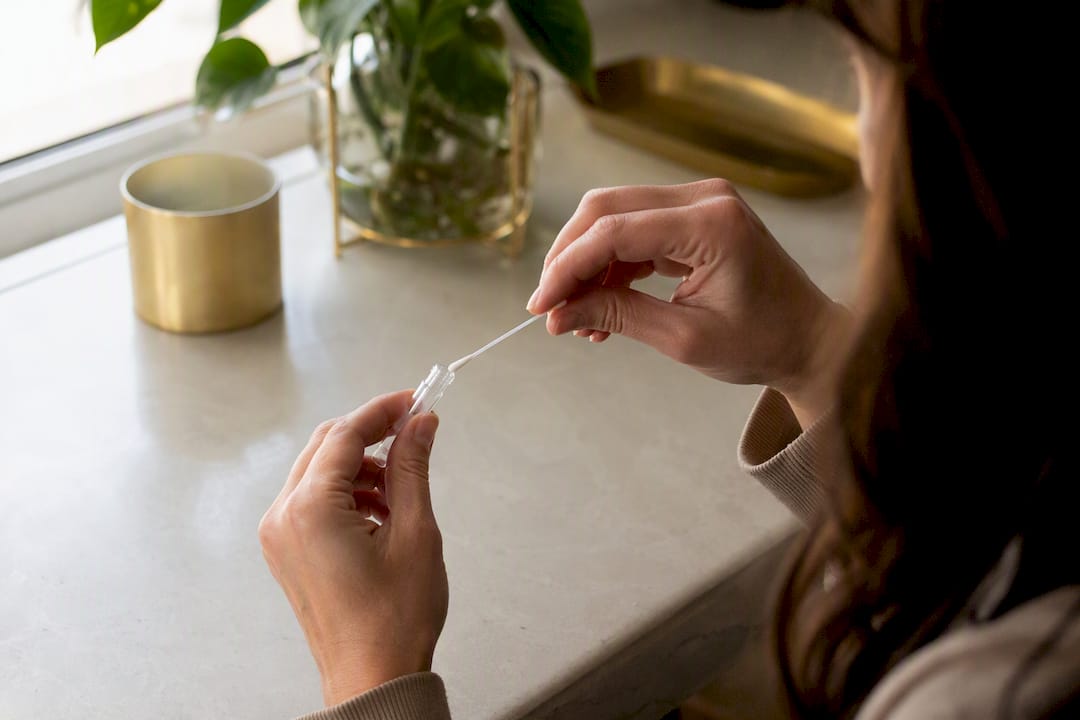 Hands collecting cheek cell epigenetic test sample